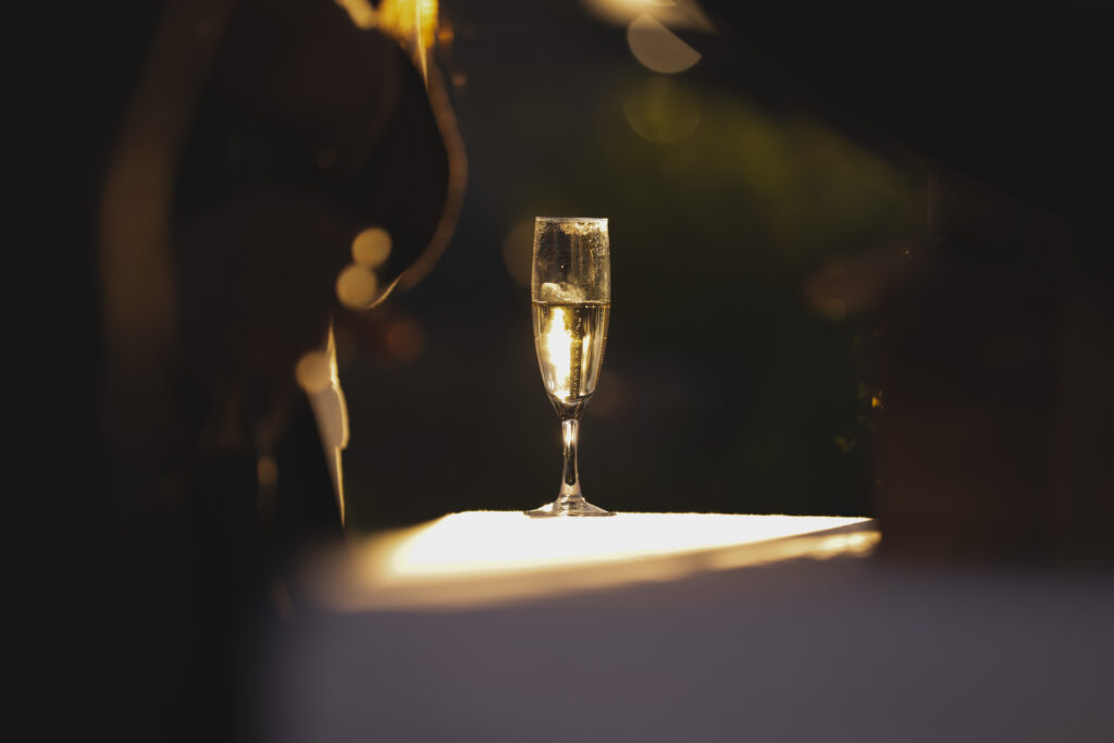 Flûte de champagne sur une table, éclairage chaud et fond flou doré.