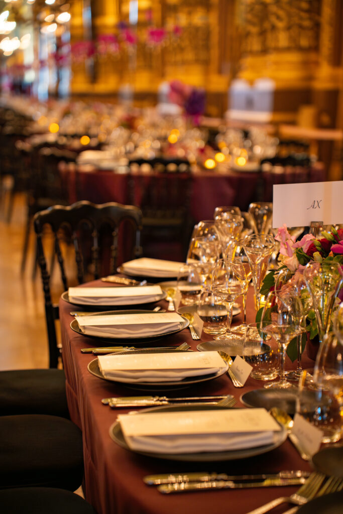 Table dressée dans un restaurant élégant : vaisselle, verres et fleurs; ambiance chaleureuse.