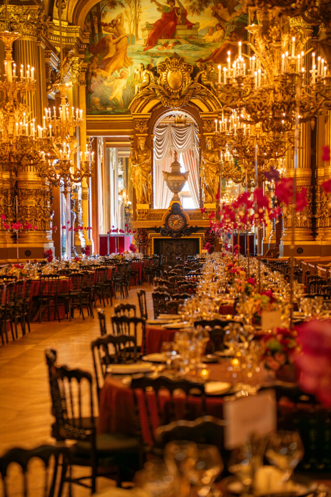 Salle de banquet baroque dorée, lustres éclatants et fresques, tables élégamment dressées.