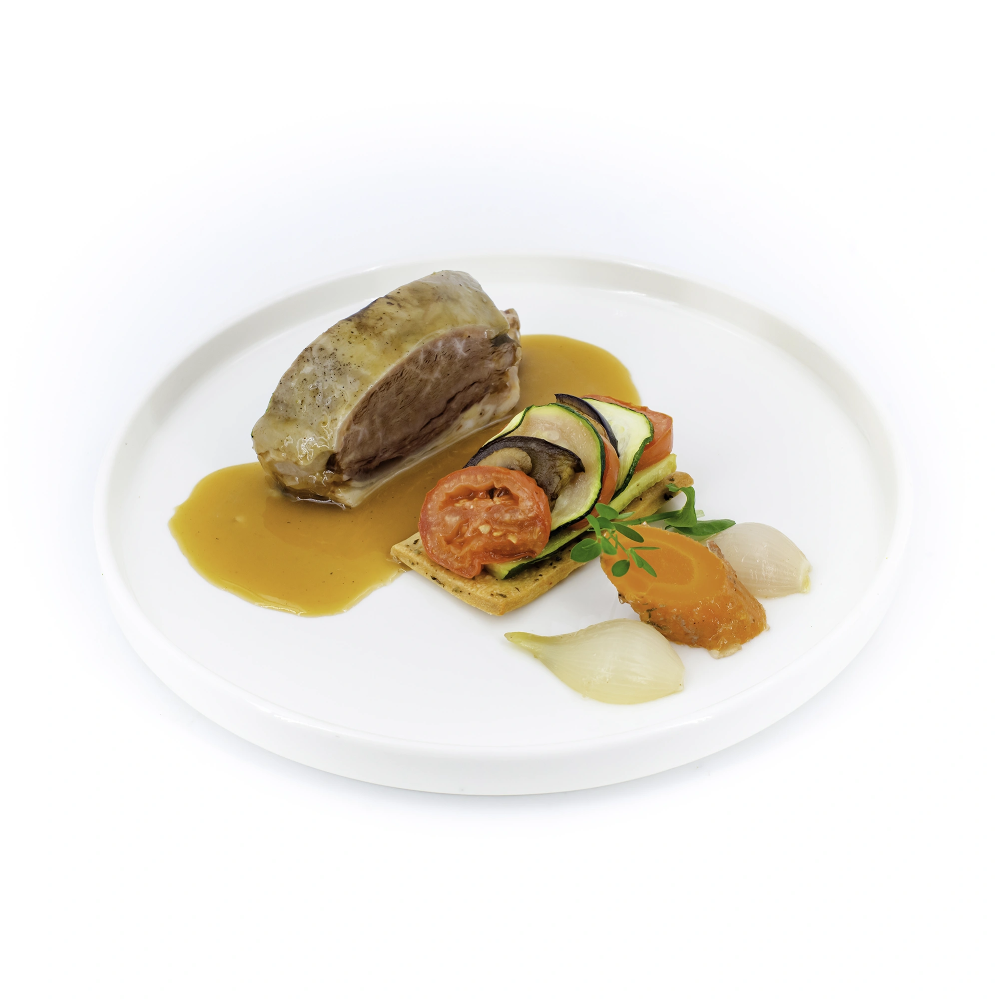 Pavé de viande nappé d'une sauce orange, accompagné de légumes colorés (courgette, tomate, carotte) sur assiette blanche.