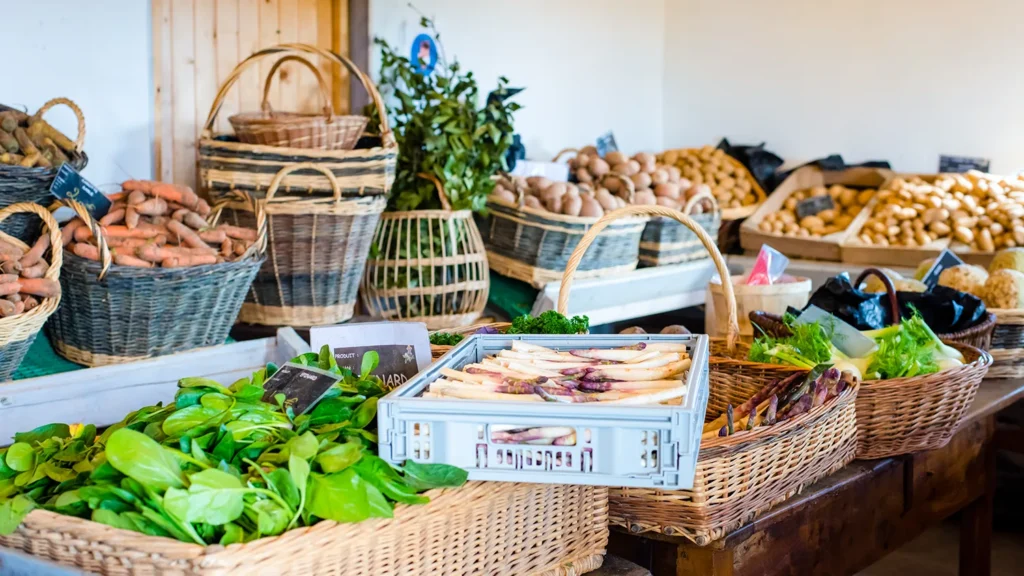 Marché de légumes frais avec paniers en osier remplis de produits locaux et herbes.