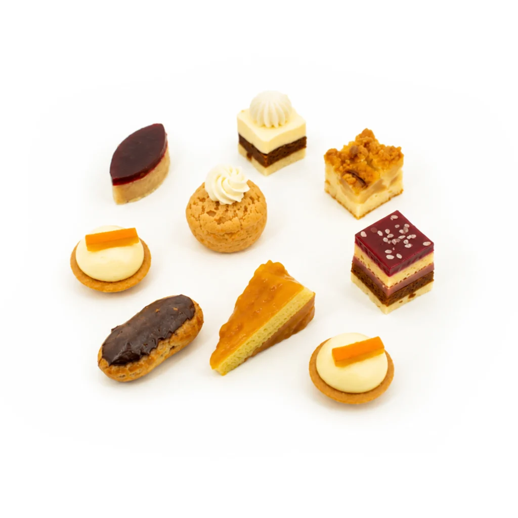 Assortiment de mini pâtisseries sur fond blanc : tartelettes, choux et petits gâteaux.