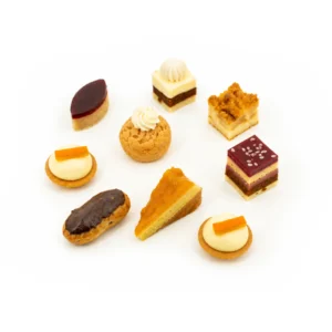 Assortiment de mini pâtisseries sur fond blanc : tartelettes, choux et petits gâteaux.