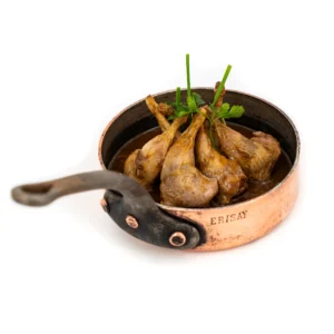 Morceaux de viande braisée dans une marmite en cuivre, garnis de ciboulette et de persil frais.
