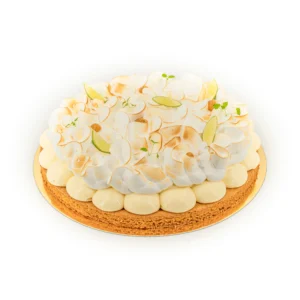 Gâteau décoré de rosaces de meringue et rondelles de citron vert, garniture d'herbes fraîches.